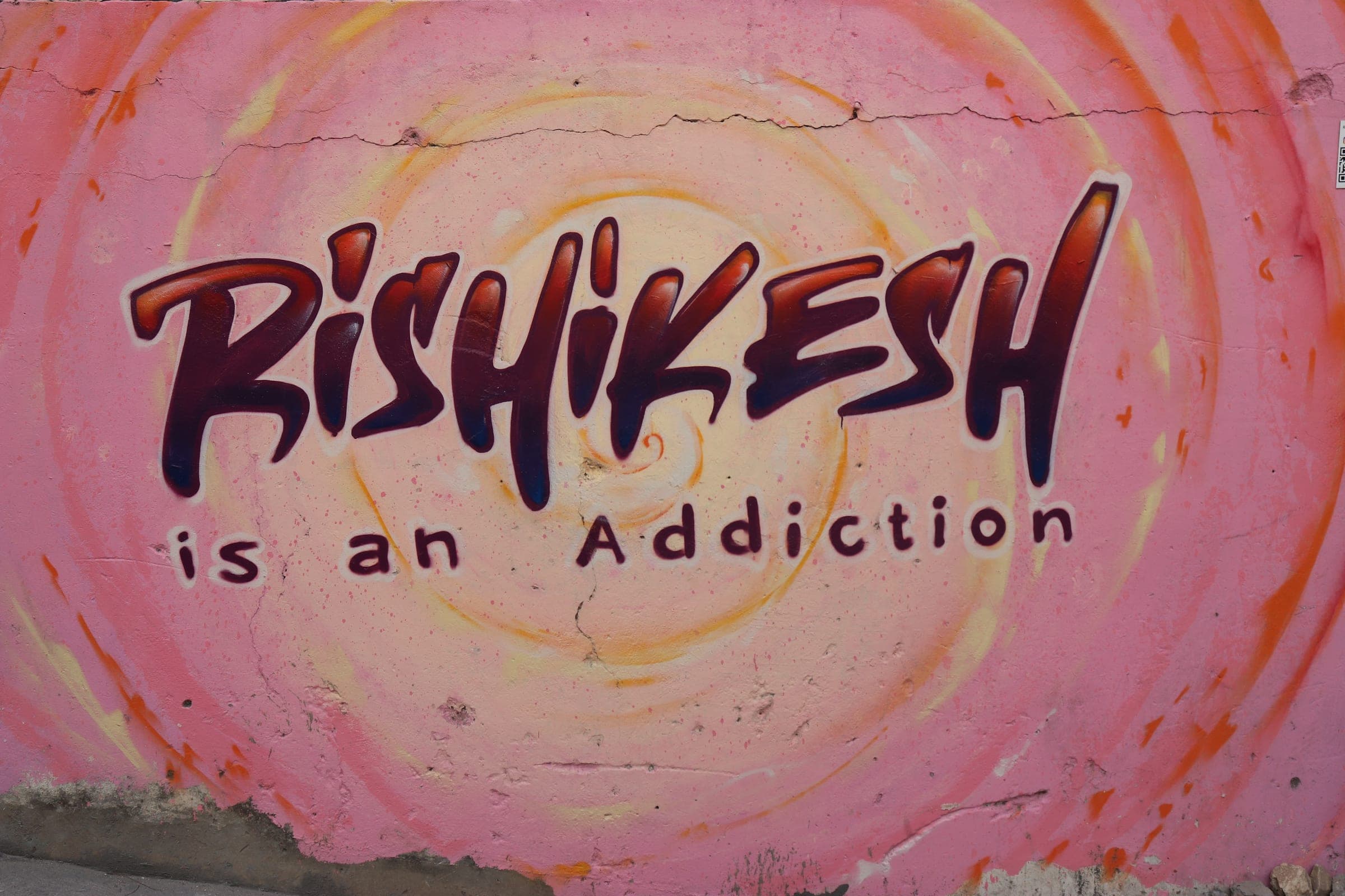 A wall in town reading Rishikesh is an Addiction
