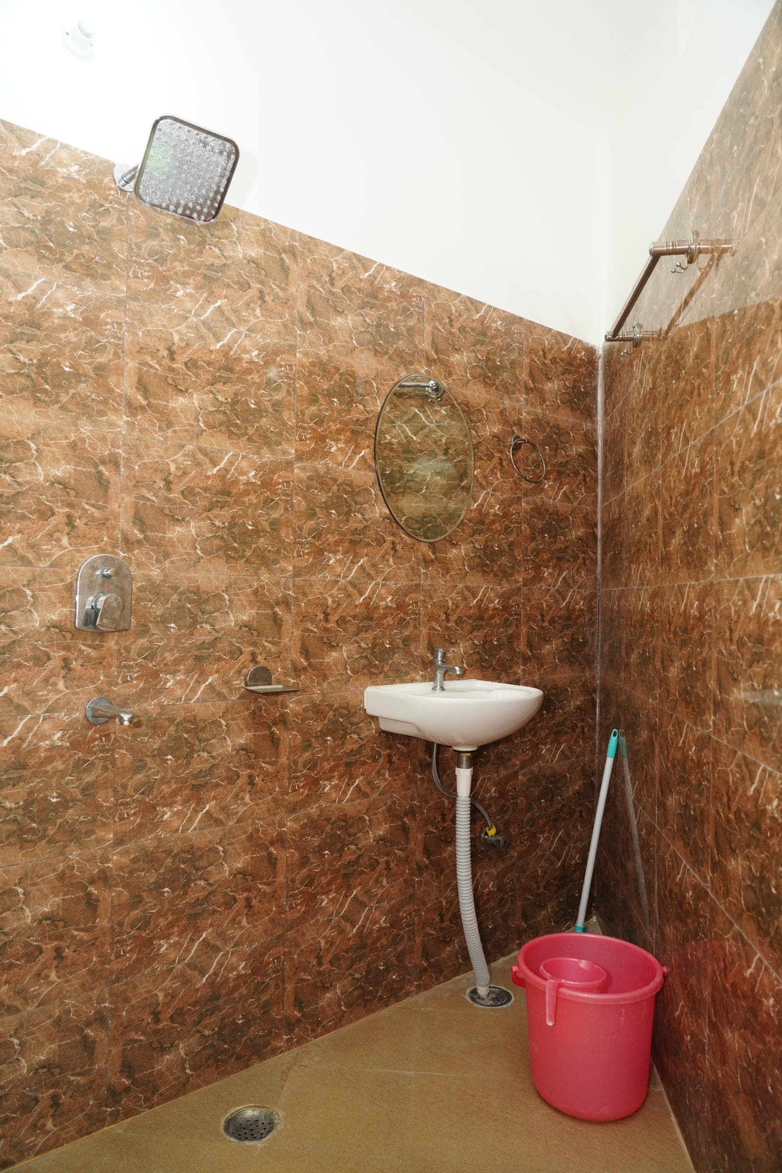 The shower and basin, tiled to the ceiling
