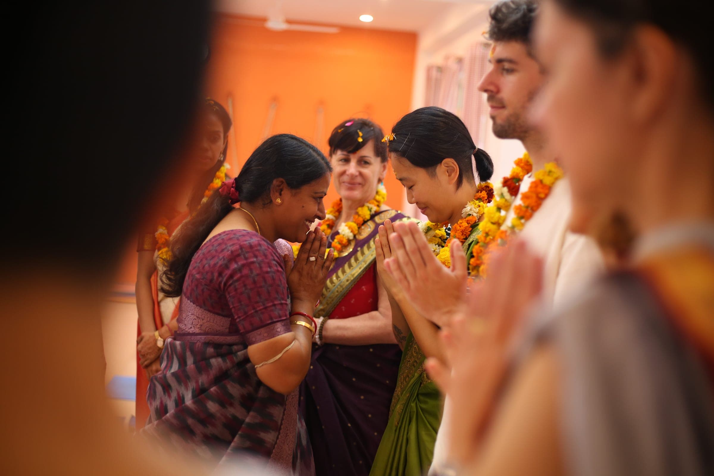 A new student welcomed with marigold garlands and folded hands on her first morning at the school