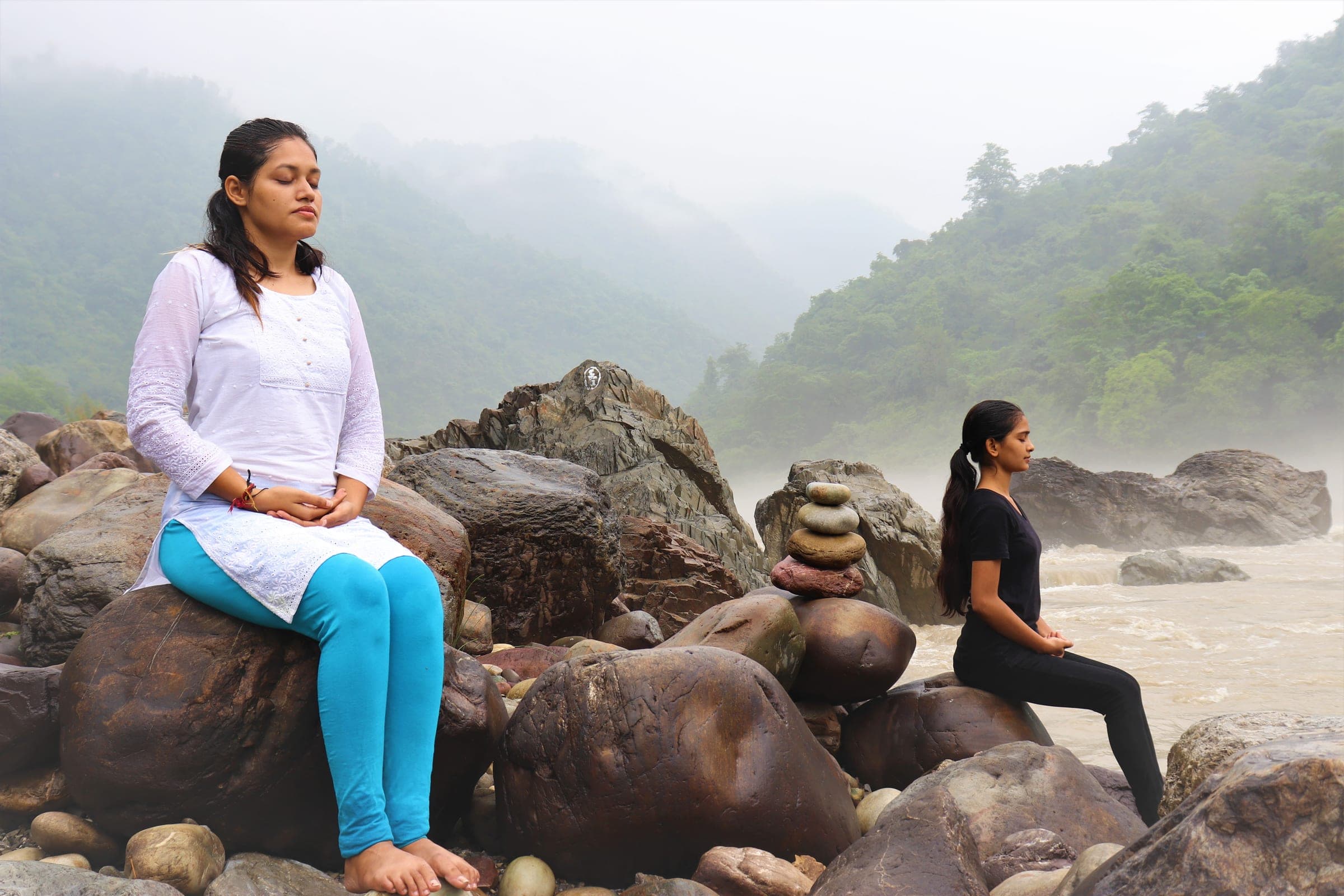 Two students meditating out on the boulders