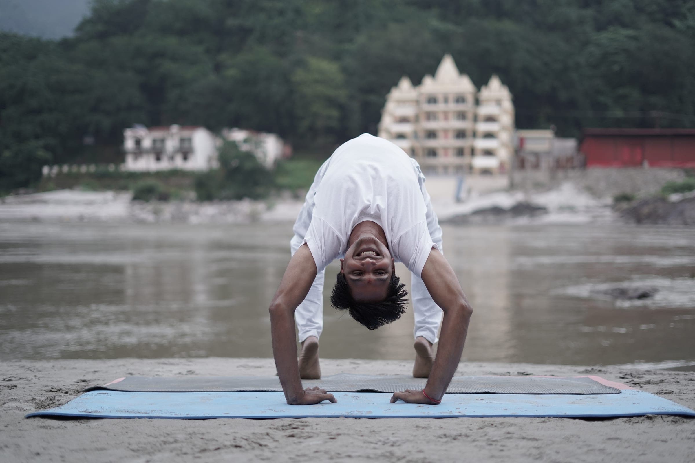 Upside down in a forward fold, and grinning